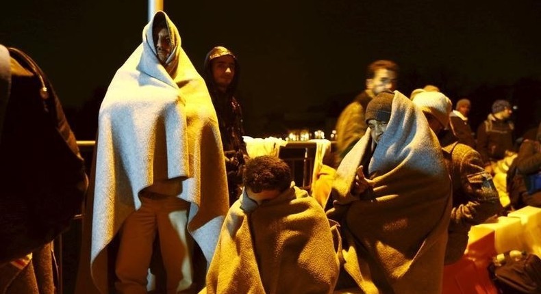 Migrants wait on the bridge at the Austrian-German border between Braunau and Simbach at lake Inn near Passau, Germany, October 27, 2015. REUTERS/Michaela Rehle