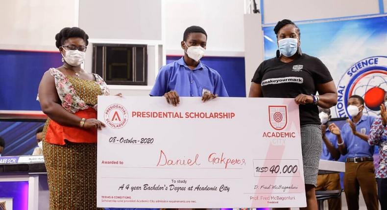 Dr Lucy Agyepong (right) and Ms Shannan Akosua Magee of Academic City presenting the scholarship to Mr Daniel Kekeli Gakpetor (middle)