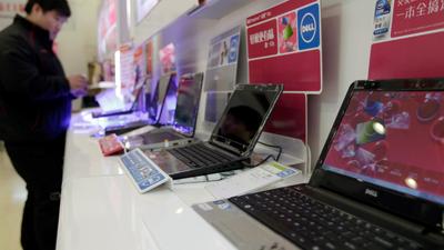 FILE PHOTO: A customer looks at laptops at a Dell outlet in Beijing December 13, 2010. REUTERS/Christina Hu