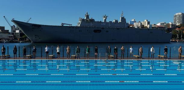 Australia's naval ship HMAS Canberra forms a backdrop as Sydney's Andrew Boy Charlton swimming poo