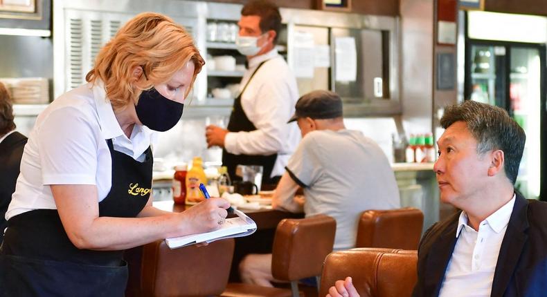 A waitress takes an order from a customer at the reopening of Langer's Delicatessen-Restaurant in Los Angeles in June 2021.

