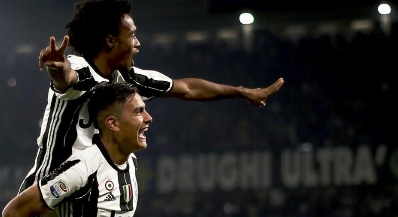 Juventus' forward Paulo Dybala (down) celebrates with Juan Cuadrado after scoring against Udinese on October 15, 2016