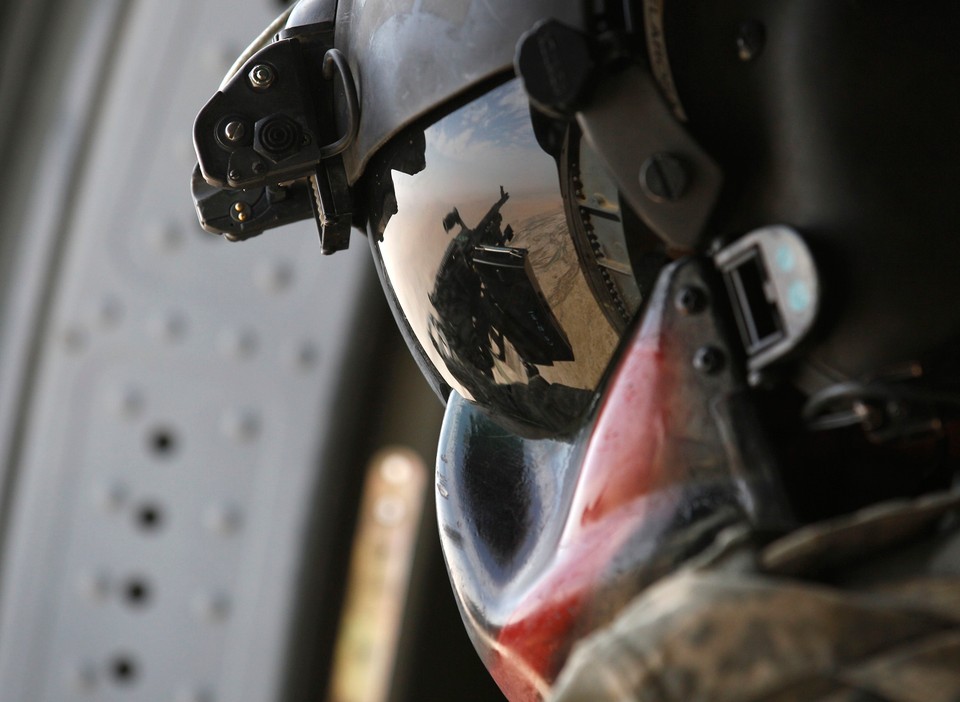 U.S. Army SPC., Jose De La Rosa, watches the ground from a chase helicopter during a Medevac mission in southern Afghanistan's Helmand Province