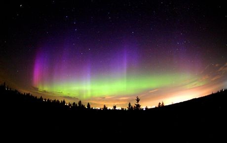 While enjoying the spaceweather on a gorgeous summer evening in mid-July, astronomer Philippe Moussette captured this colorful fish-eye lens view looking north from the Observatoire Mont Cosmos, Quebec, Canada, planet Earth. In the foreground, lights along the northern horizon give an orange cast to the low clouds. But far above the clouds, at altitudes of 100 kilometers or more, are alluring green and purple hues of the aurora borealis or northern lights, a glow powered by energetic particles at the edge of space. In the background are familiar stars of the northern sky. In particular, that famous celestial kitchen utensil, the Big Dipper (left), and the W-shaped constellation Cassiopeia (right) are easy to spot. Then, just follow the pointer stars of the Big Dipper to Polaris, perhaps the most famous northern light of all.