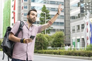 Young White Man Holding A Cellphone Hailing Uber Taxi