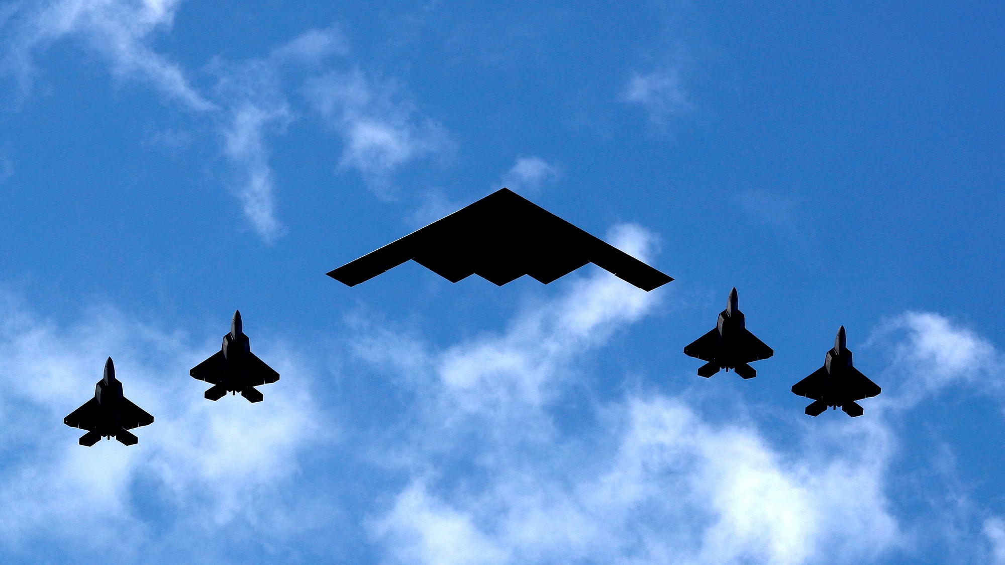 Americký bombardér B-2 Spirit Stealth (v strede) je sprevádzaný štyrmi stíhačkami F-35 americkej námornej pechoty