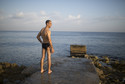 A man prepares to enter the sea in Havana