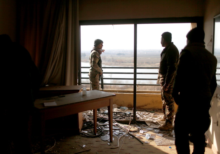 Iraqi soldiers looking out from a damaged room in the Ninewah Oberoi Hotel in Mosul.