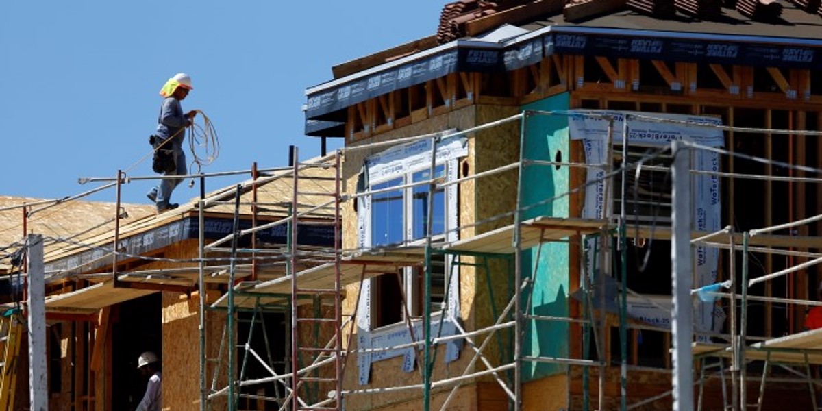 A worker walks on scaffolding at the construction site of a new home in Carlsbad