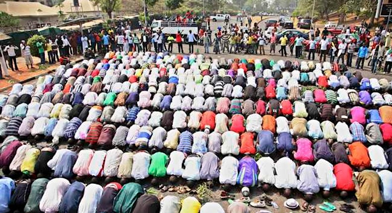 Muslims pray while Christians form a protective human chain around them during a protest against the elimination of a popular fuel subsidy that has doubled the price of gas in Nigeria's capital Abuja, Jan. 10, 2012.