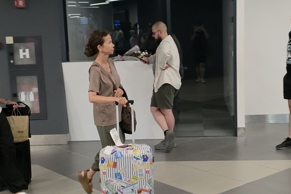 PRIRODNA LEPOTA JE UVEK U MODI! Uslikali smo poznatu voditeljku (57) bez trunke šminke na aerodromu: Vuče kofer puna samopouzdanja i privlači pažnju (Video)