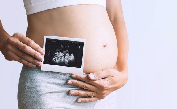 Kobieta w ciąży trzyma wynik USG