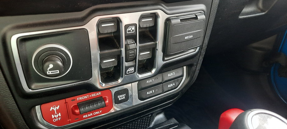 Jeep Wrangler Unlimited 4Xe - na środkowym panelu możemy, za pomocą przycisków, włączać i wyłączać blokady mechanizmów różnicowych, jak również, gdy to potrzebne - da się odłączyć przedni stabilizator.