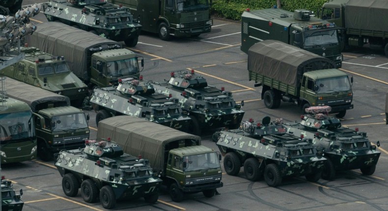 Thousands of Chinese military personnel waving red flags paraded at a sports stadium in Shenzhen, a Chinese city across the border from Hong Kong