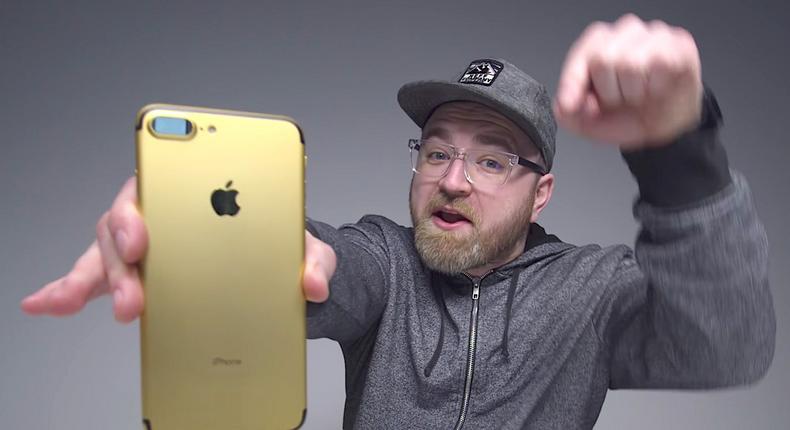 Unbox Therapy's Lew Hilsenteger holding a custom gold iPhone 7.