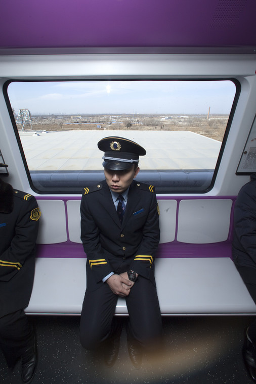 Chińskie metro: pracownik metra podróżujący nową linią metra w Pekinie