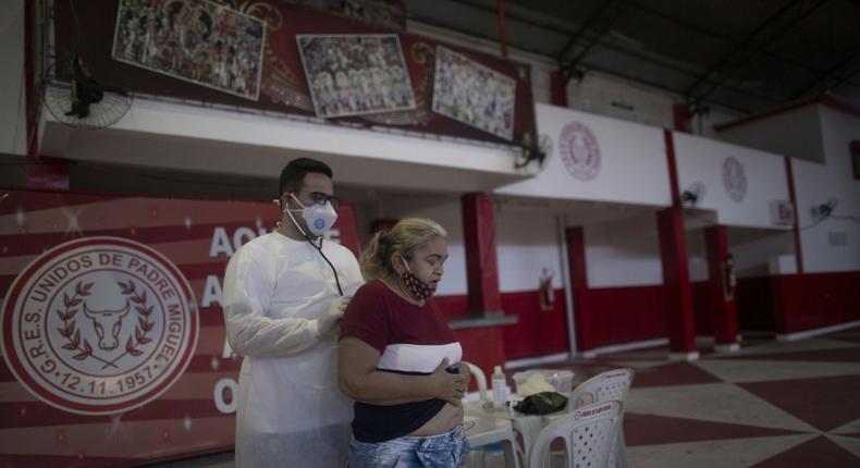 A doctor examines a woman showing symptoms of the novel coronavirus, COVID-19, during a day of free health checks at a samba school in Rio de Janeiro, Brazil, on May 24, 2020