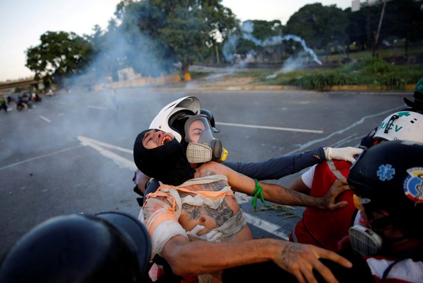 An injured opposition supporter is helped by volunteer members of a primary care response team durin