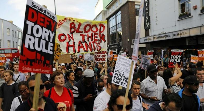 Protesters march along Notting Hill Gate after a gathering at Kensington Town Hall on June 16, as they demand justice for those affected by the fire that gutted Grenfell Tower