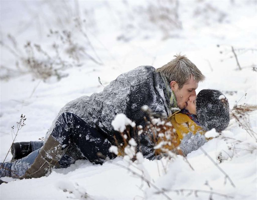 Majka całuje się na śniegu. Foto