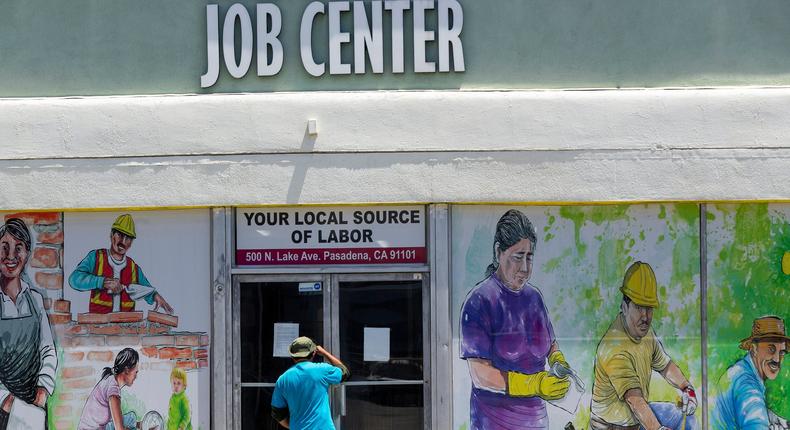 FILE - In this May 7, 2020 file photo, a person looks inside the closed doors of the Pasadena Community Job Center in Pasadena, Calif., during the coronavirus outbreak. California's unemployment rate continued to climb in May, reaching 16.3% as businesses continued to lay people off because of a state-at-home order aimed at slowing the spread of the coronavirus that has wrecked the state's economy.  (AP Photo/Damian Dovarganes, File)