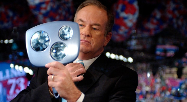 Television commentator Bill O'Reilly checks himself in a mirror prior to interviewing Bono, lead singer of the Irish rock group U2, during the third night of the 2004 Republican National Convention, at Madison Square Garden in New York, September 1, 2004.