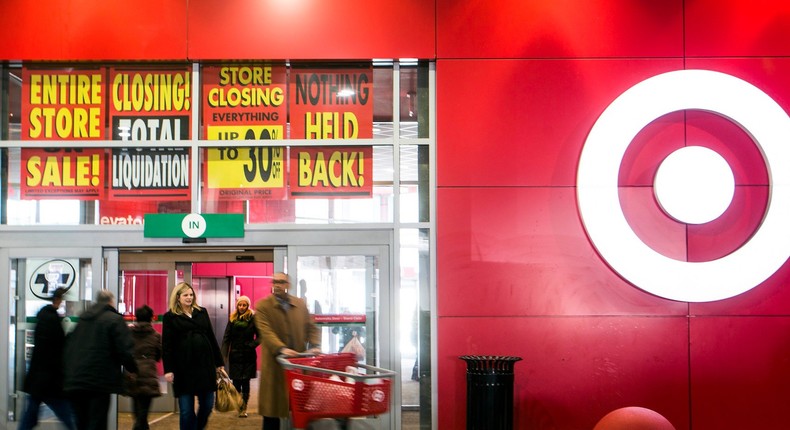 People walk out of the going-out-of-business sale at Target Canada in Toronto.