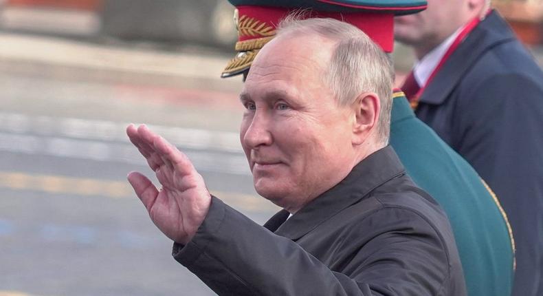 Russian President Vladimir Putin waves his hand at Russia's Victory Day parade in Moscow on May 9, 2022