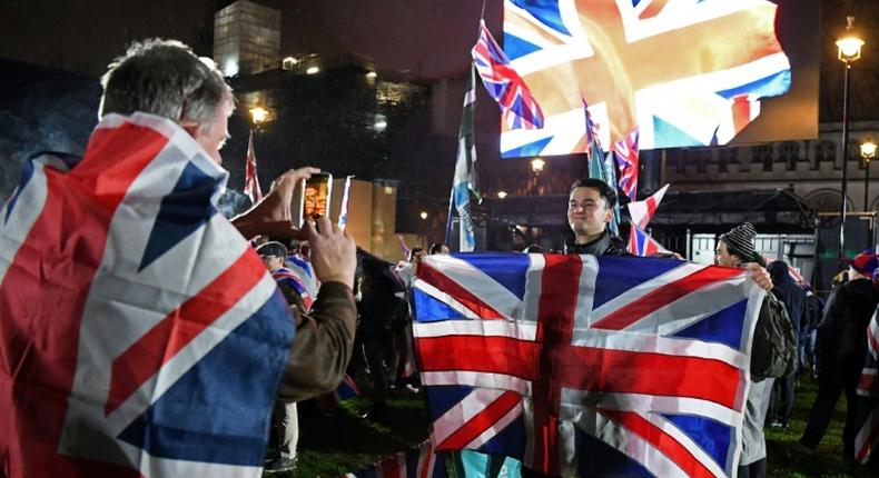 A Brexit supporter poses for a photograph with a Union flag as he waits for the festivities to begin [Study International]