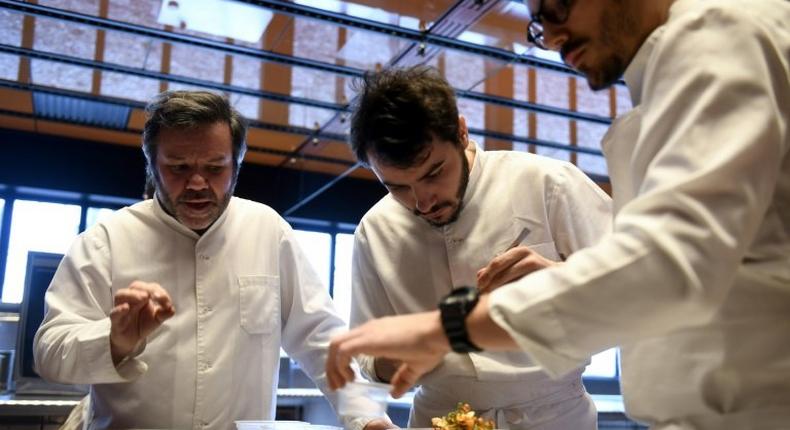 Michel Troisgros (L) cooks with his sons Cesar (R) and Leo in the new Troisgros restaurant, a veritable shrine to France's haute cuisine