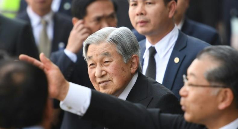 Japan's Emperor Akihito (C) flanked by security men arrives at Phu Bai airport in Vietnam's central city of Hue as they prepare to depart for Thailand, ending their six-day long royal visit in the communist country on March 5, 2017