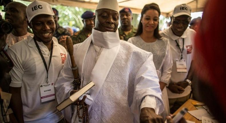 Incumbent Gambian president Yahya Jammeh (C) has his finger inked before casting his marble in Banjul on December 1, 2016