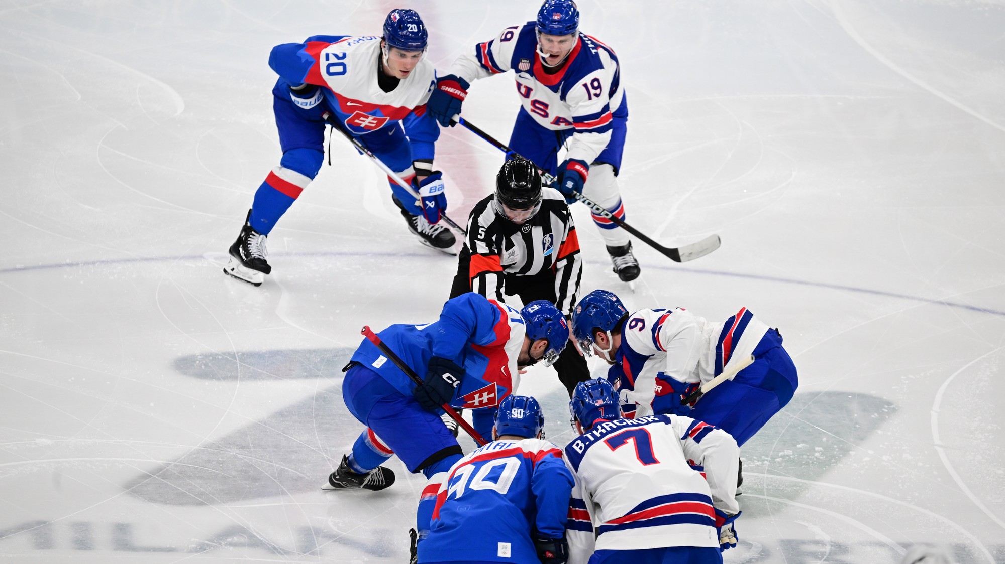 Slovenskí hokejoví reprezentanti kapitán Tomáš Tatar (90), Adam Ružička (21) a Juraj Slafkovský (20) stoja pred úvodným vhadzovaním. 