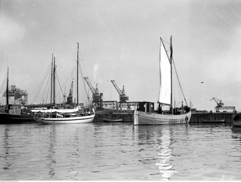  Statek dozorczy "Gazda" (z lewej) oraz kuter "Tryton" (z prawej) stojące w przystani rybackiej w Gdyni. Widoczne portowe urządzenia przeładunkowe