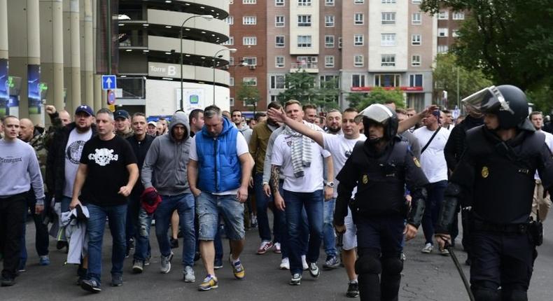 Legia Warsaw football fans are escorted by Spanish police into stadium ahead of the match between Real Madrid and Legia Warszawa at the Santiago Bernabeu stadium in Madrid on October 18, 2016