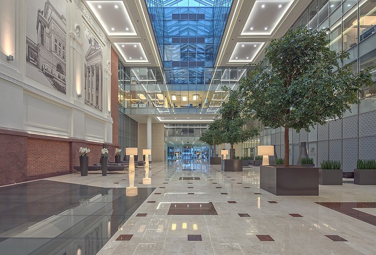 Część podłogi w Atrium została przeszklona, by zaprezentować zabytkowe fragmenty murów mennicy króla Stanisława Augusta Poniatowskiego z XVIII wieku. Zdjęcie: biurowiec Senator - atrium główne, fot. Ghelamco