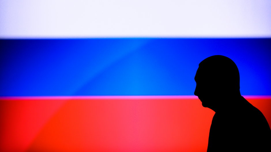 Cień Władimira Putina na tle rosyjskiej flagi