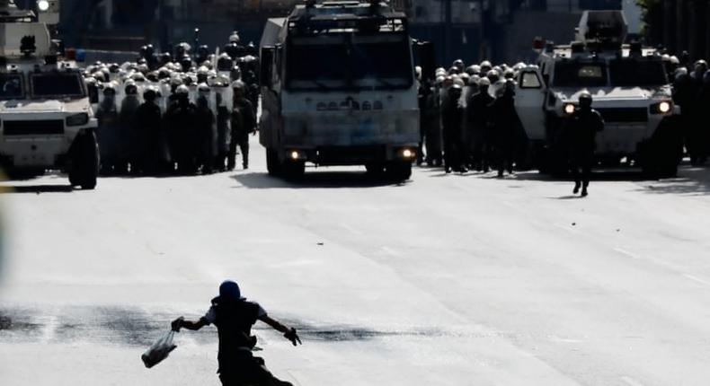 Riot security forces taking position while clashing with demonstrators rallying against Venezuelan President Nicolas Maduro in Caracas, Venezuela.