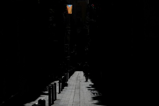 A bird flies past a man walking underneath an Estelada (Catalan separatist flag) four days after the