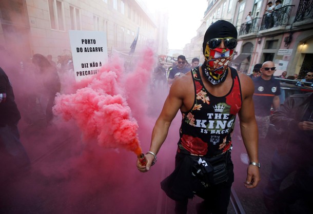 Dockers hold up flares during a protest against what they say is a lack of job stability in Lisbon, 