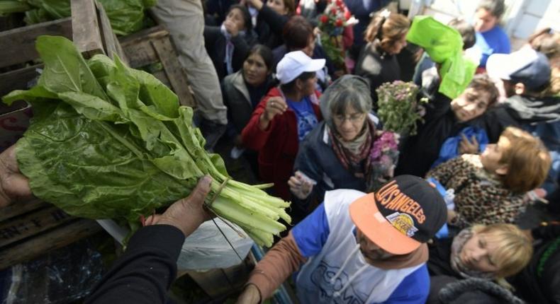 Farmers give away vegetables during a protest at Plaza de Mayo square near the Casa Rosada presidential palace in Buenos Aires, on April 26, 2017