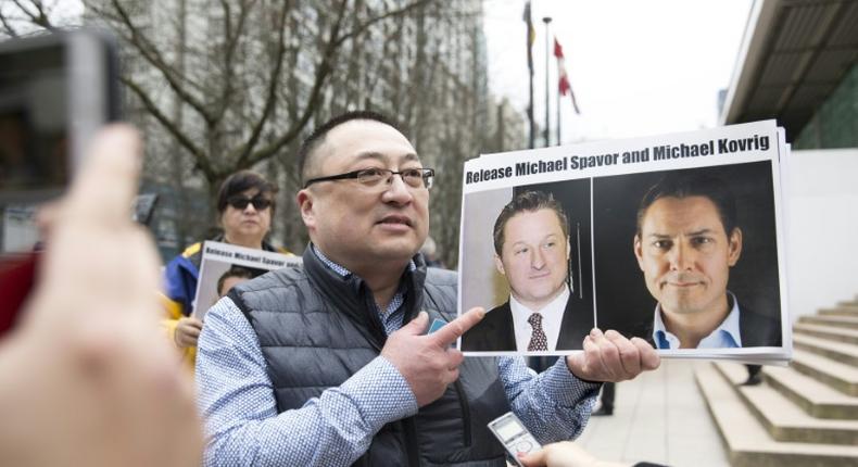 Louis Huang of Vancouver Freedom and Democracy for China holding photos of Canadians Michael Spavor and Michael Kovrig