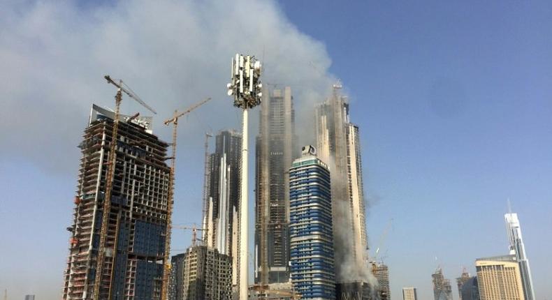 Smoke billows near the Dubai Mall and Burj Khalifa, the world's tallest building, after a fire hit the construction site in Dubai on April 2, 2017