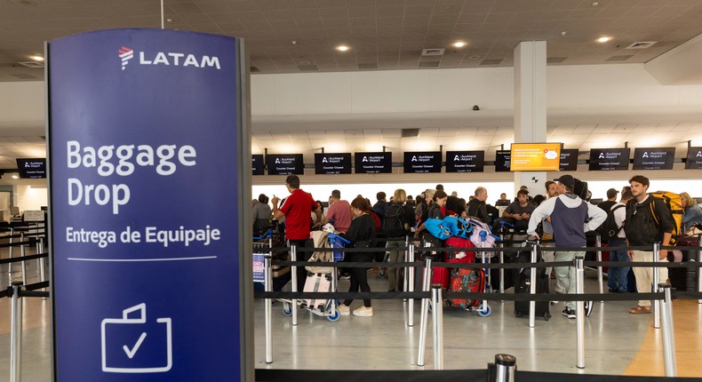 Passengers stand at the LATAM Airlines check-in counters at Auckland International Airport on March 12, 2024, after the midair drop.Brett Phibbs/AFP via Getty Images