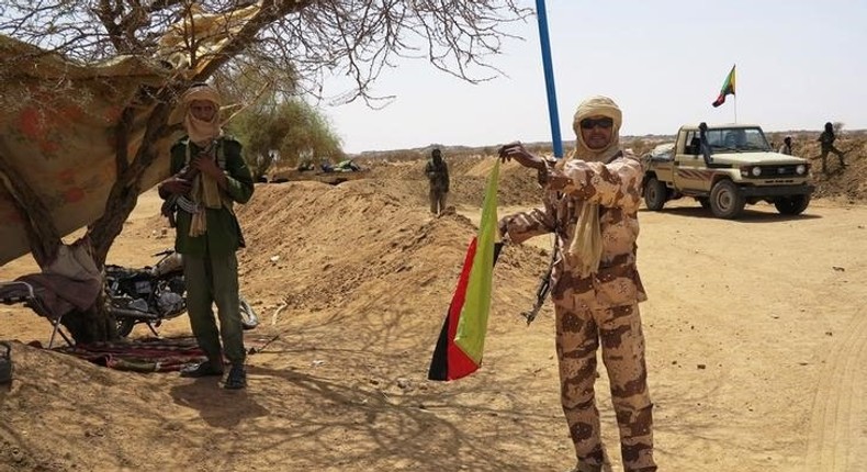 A fighter with the Tuareg separatist group MNLA (National Movement for the Liberation of Azawad) brandishes a separatist flag for the region they call Azawad outside the local regional assembly, where members of the rebel group met with the Malian army, the U.N. mission in Mali and French army officers, in Kidal June 23, 2013. REUTERS/Adama Diarra