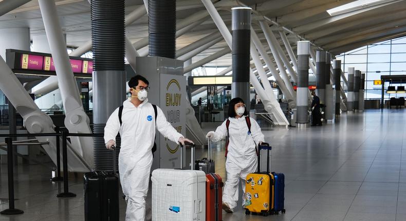 NEW YORK, NEW YORK   APRIL 16  Travelers, some in protective gear, walk through John F. Kennedy Airport (JFK) as it stands mostly empty due to the