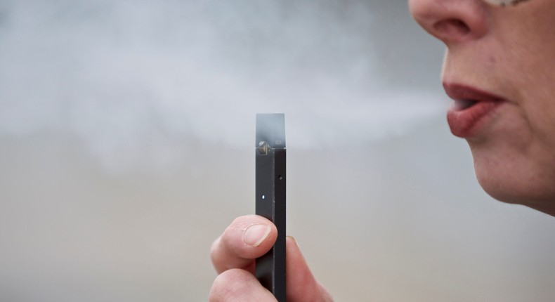 A woman exhales a puff of vapor from a Juul pen in Vancouver, Wash.