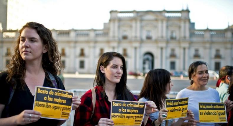 Activists hold signs reading Stop criminalizing women, Free and safe abortion and Verbal, sexual or institutional, it is violence anyway during a pro-abortion demo on November 11, 2014
