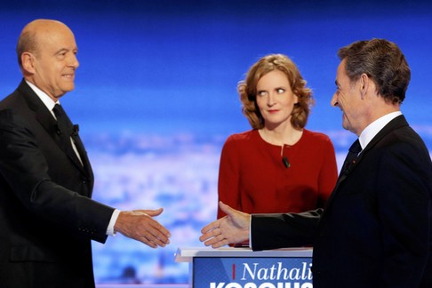 French politicians Alain Juppe and Nicolas Sarkozy shake hands as Nathalie Kosciusko-Morizet looks 