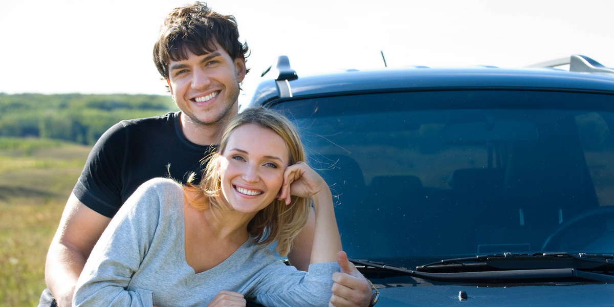 couple standing near the new car